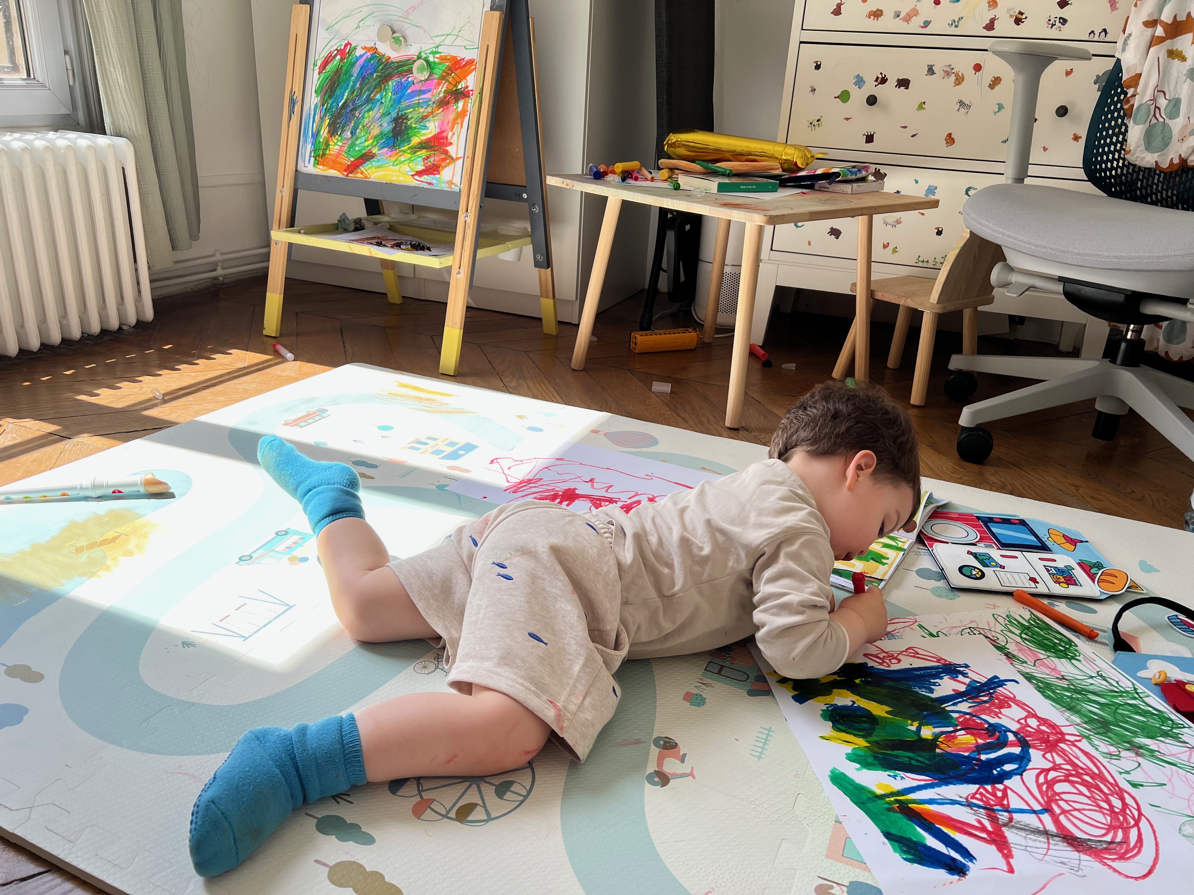 Child doing imperfect art on the floor